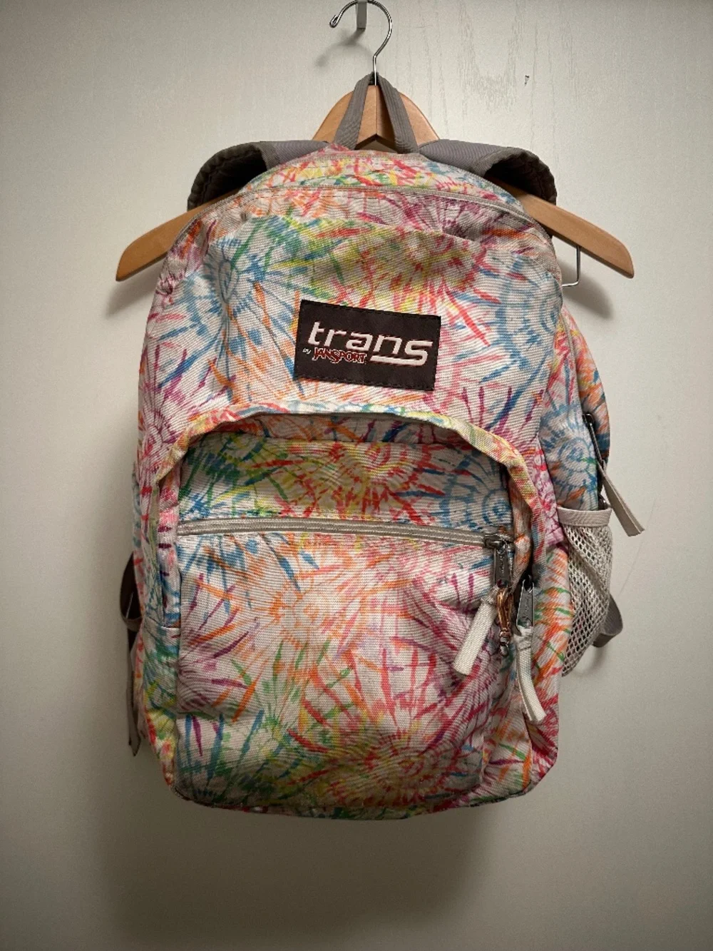 JanSport Trans backpack in a colorful multicolor floral/tie-dye style print